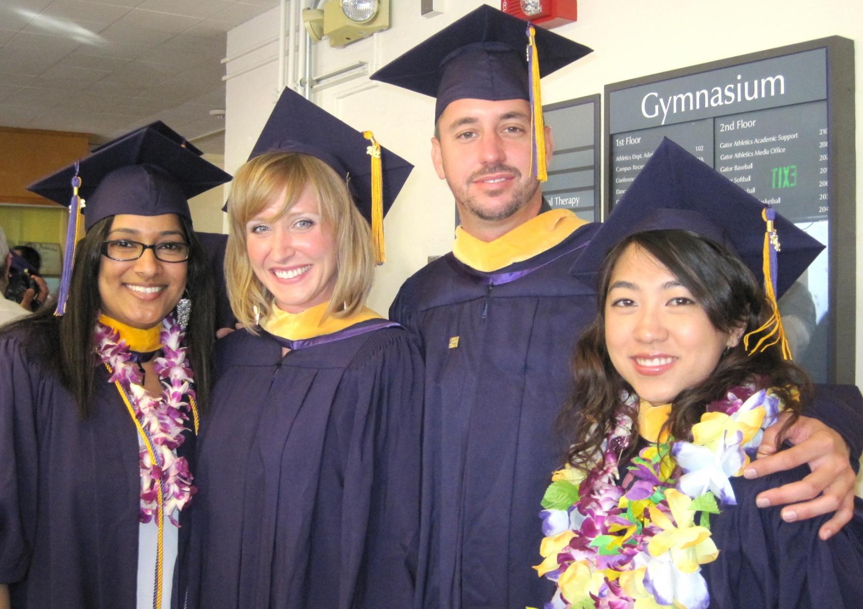 Photo of four class of 2012 graduate students wearing caps and gowns 